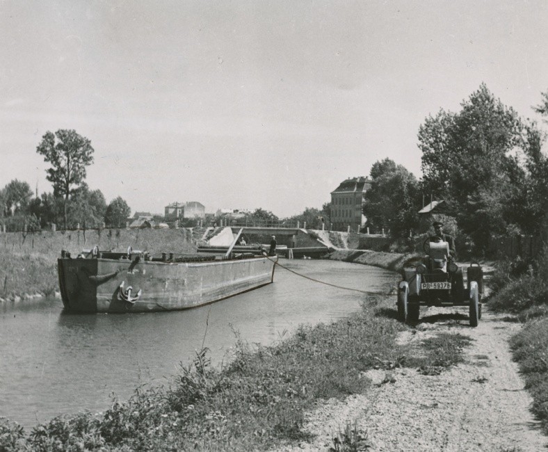Vlečný člun na plavebním kanále tažený traktorem. Foto Státní okresní archiv Zlín